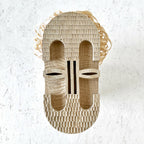 Masque décoratif en fibres de paille tressées, ouvertures yeux et bouche en relief.