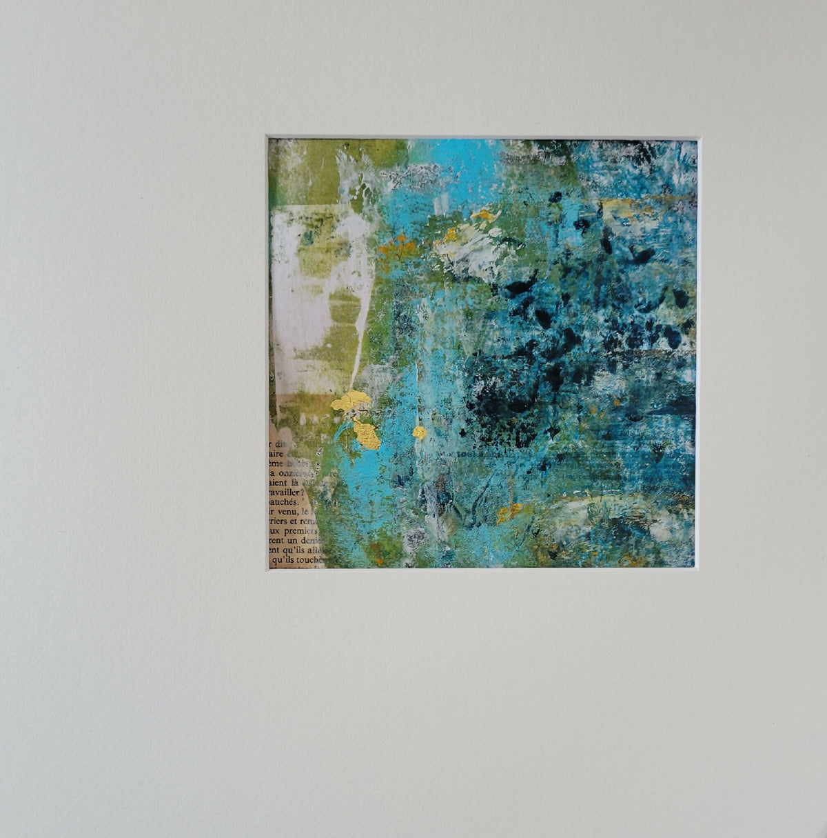 Tableau abstrait encadré, bleu et vert avec touches jaunes et blanches.