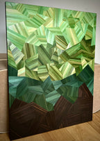 Tableau posé : motif en cubes verts et motifs facettés, base brun foncé, cadre noir.