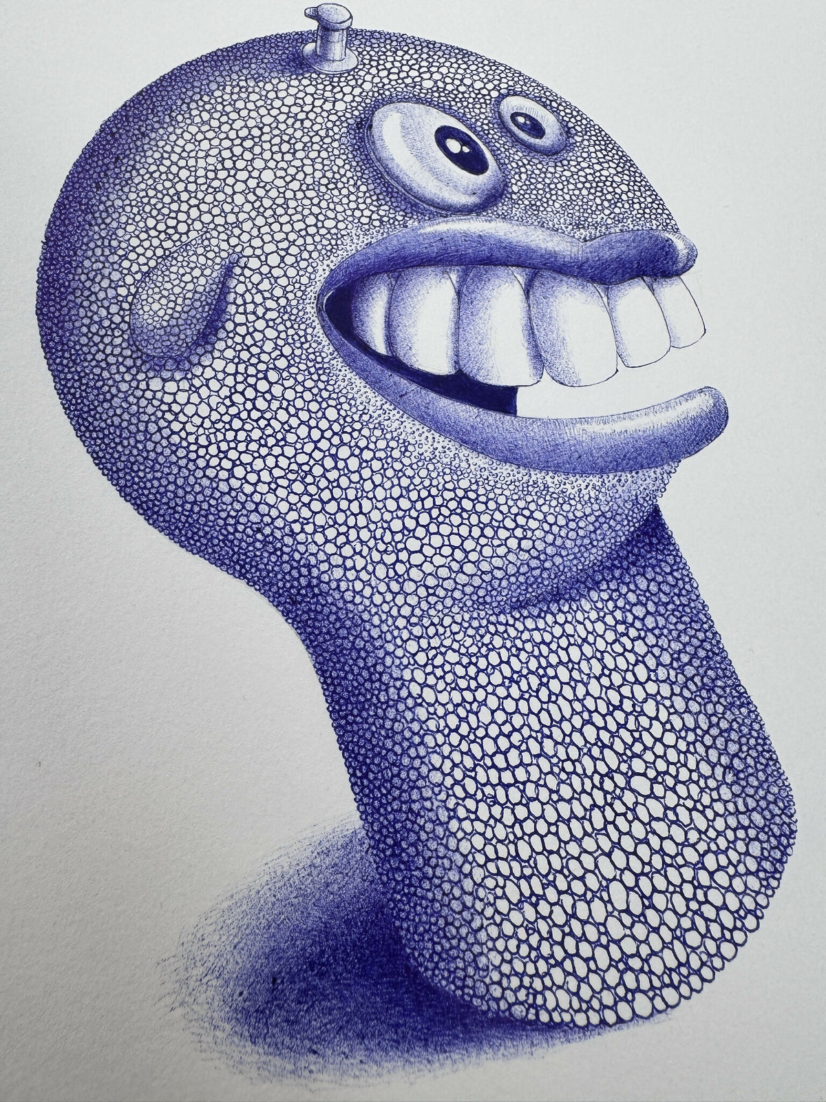 Figurine tête de monstre bleue de profil, grandes dents, yeux ronds, texture pailletée