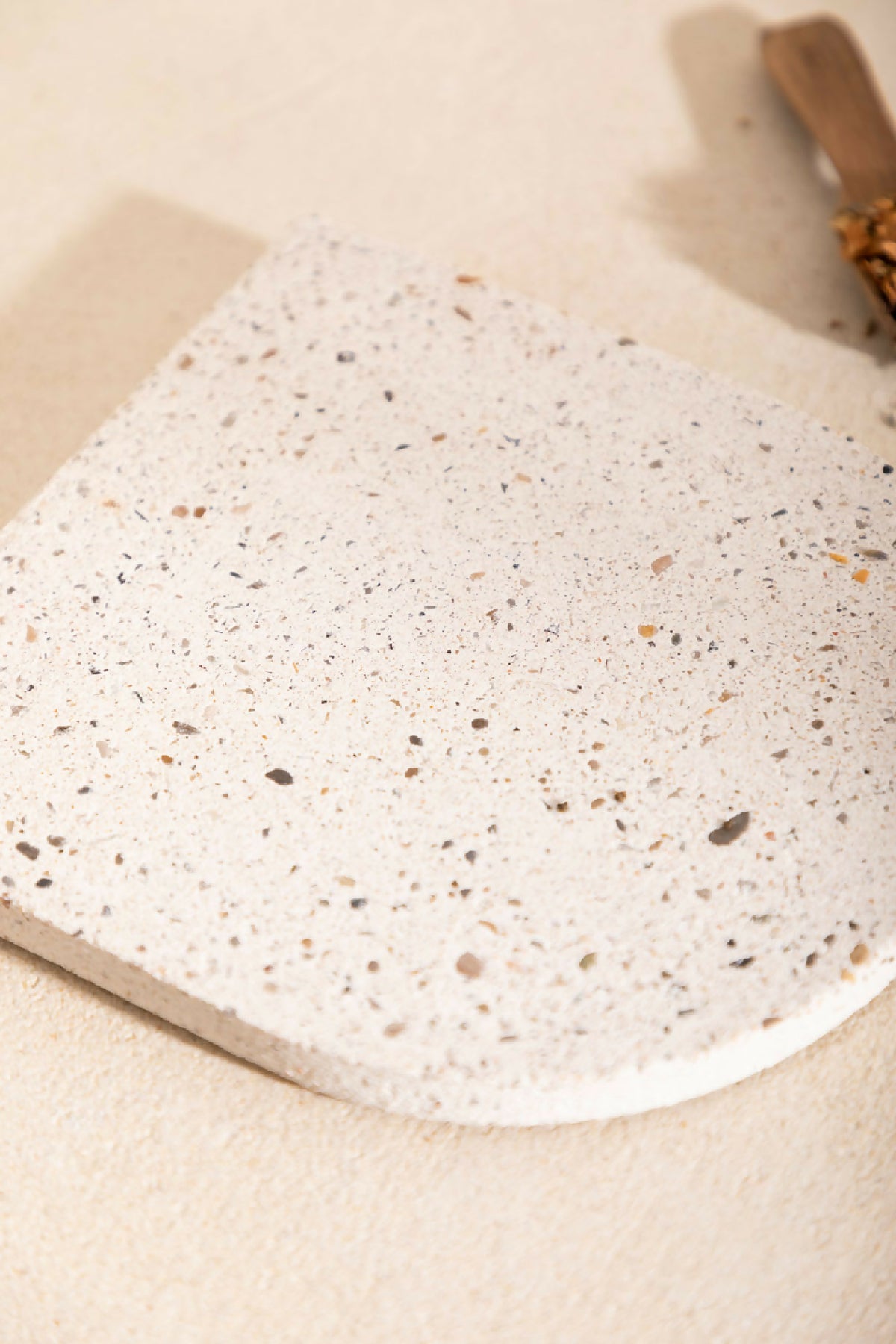 Dessous de plat LIO beige clair moucheté, vue rapprochée de la texture granuleuse