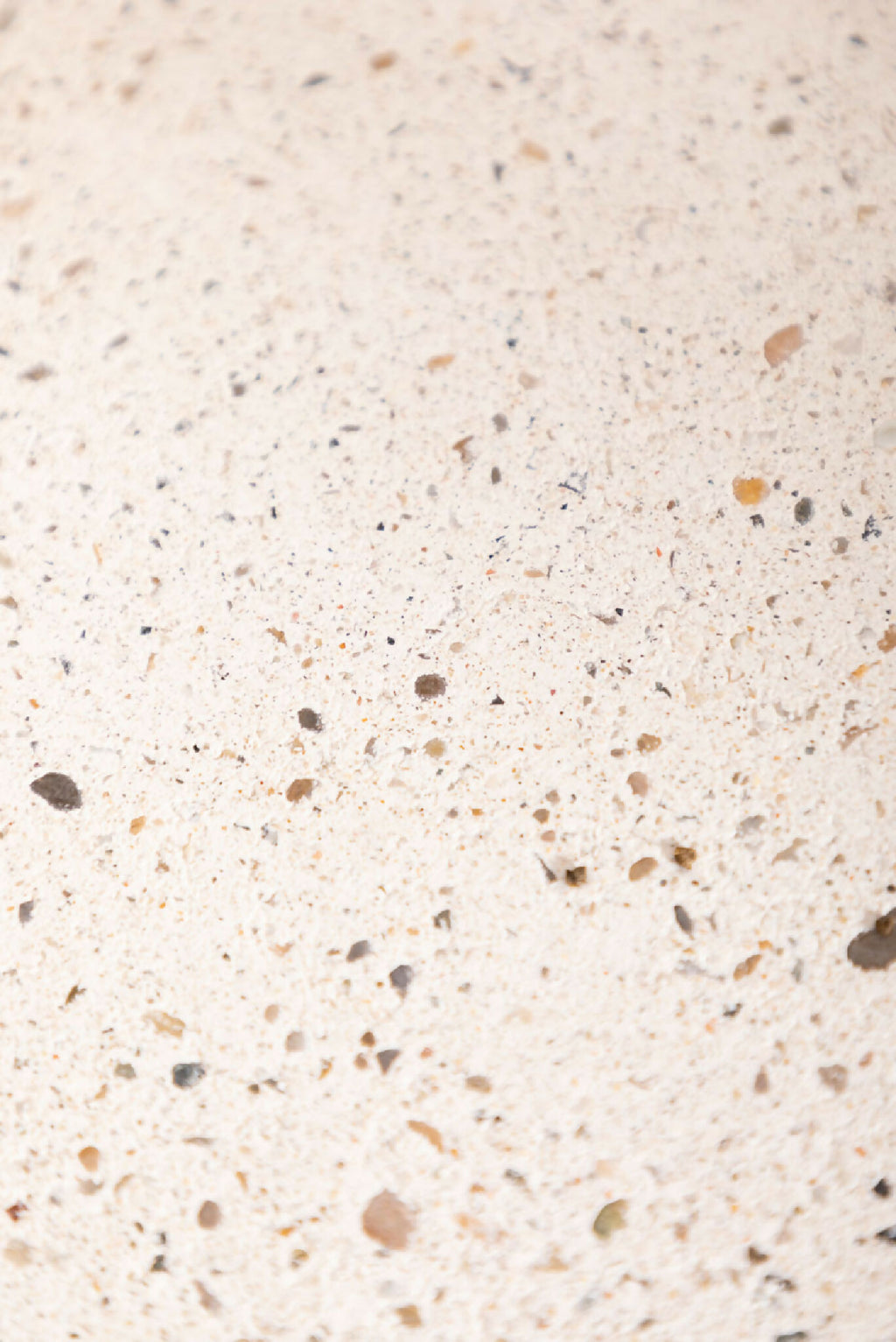 Dessous de plat LIO beige clair, gros plan sur la surface granuleuse et les petites taches