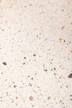 Dessous de plat LIO beige clair, gros plan sur la surface granuleuse et les petites taches