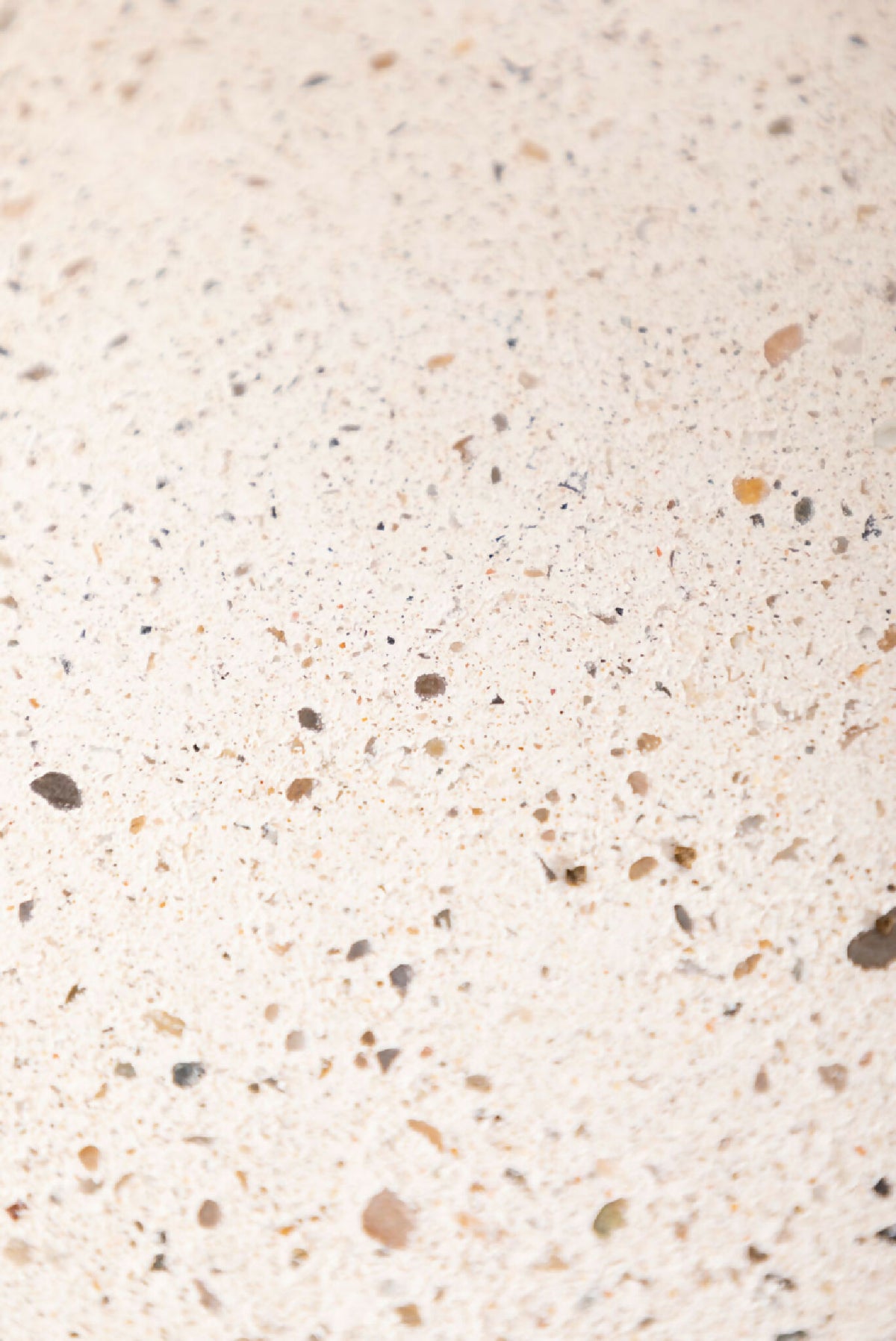 Dessous de plat LIO beige clair, gros plan sur la surface granuleuse et les petites taches