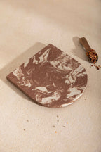 Dessous de plat LIO marron à marbrures blanches, bord arrondi, aspect enduit