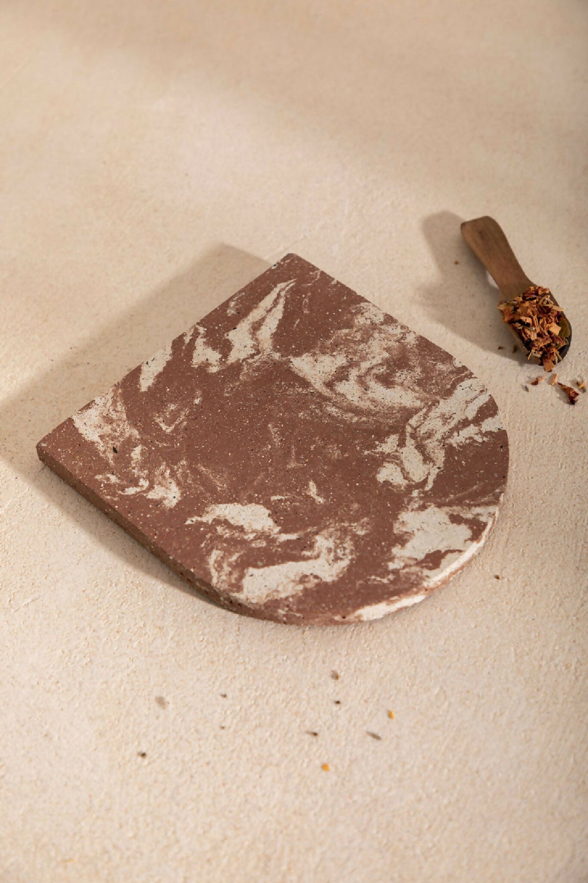 Dessous de plat LIO marron à marbrures blanches, bord arrondi, aspect enduit
