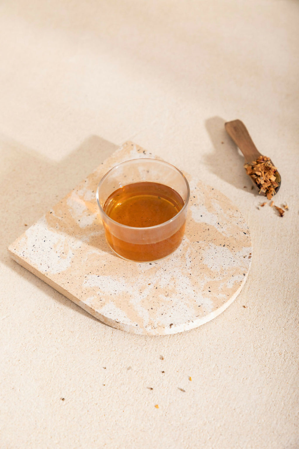 Dessous de plat rectangulaire beige tacheté, avec tasse de boisson ambrée
