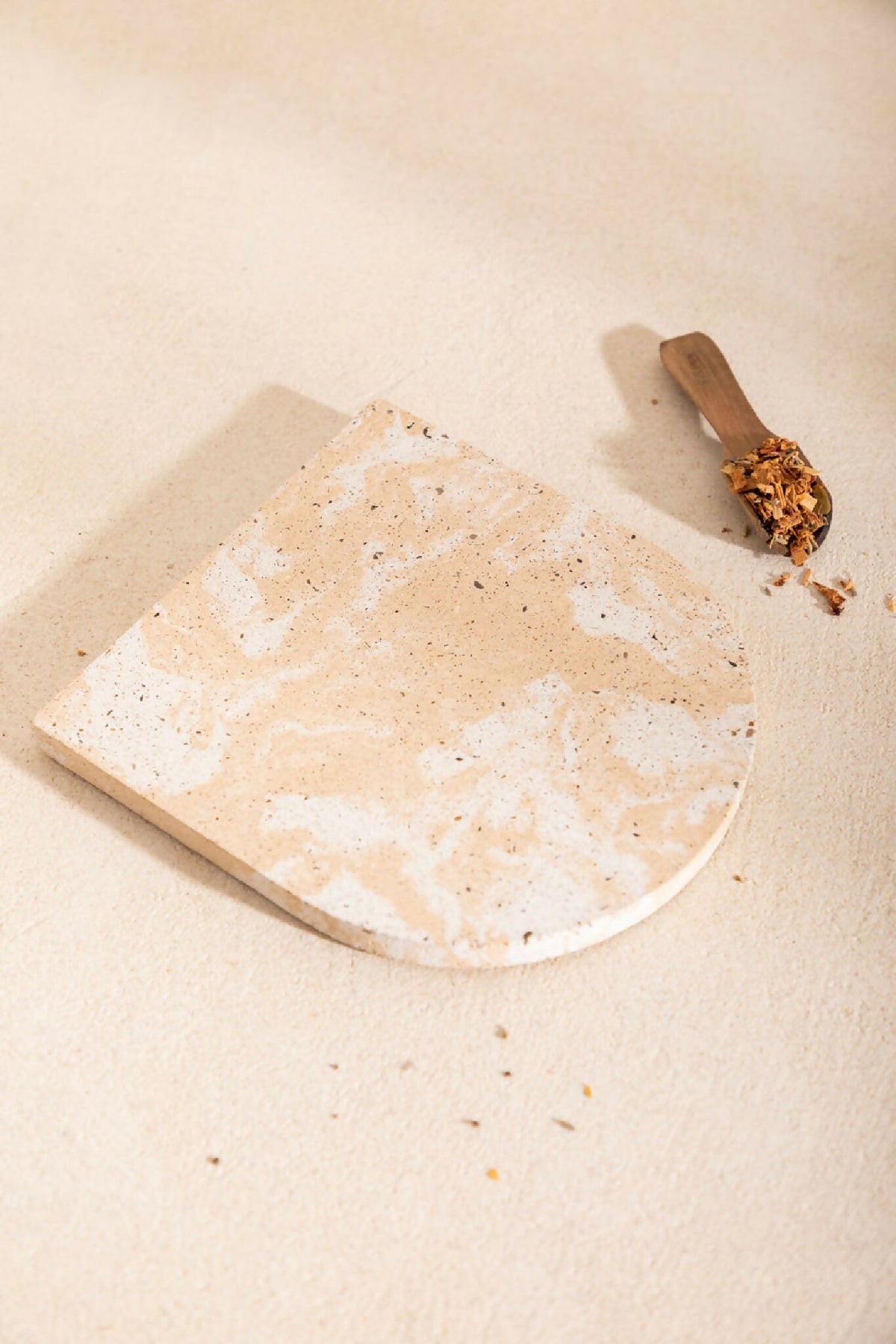 Dessous de plat LIO en pierre beige clair, bord arrondi, aspect granuleux avec taches