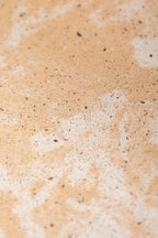 Dessous de plat beige tacheté, vue rapprochée de la surface