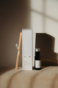 Diffuseur à bâtonnets avec flacon brun et tiges en bois, coffret blanc assorti