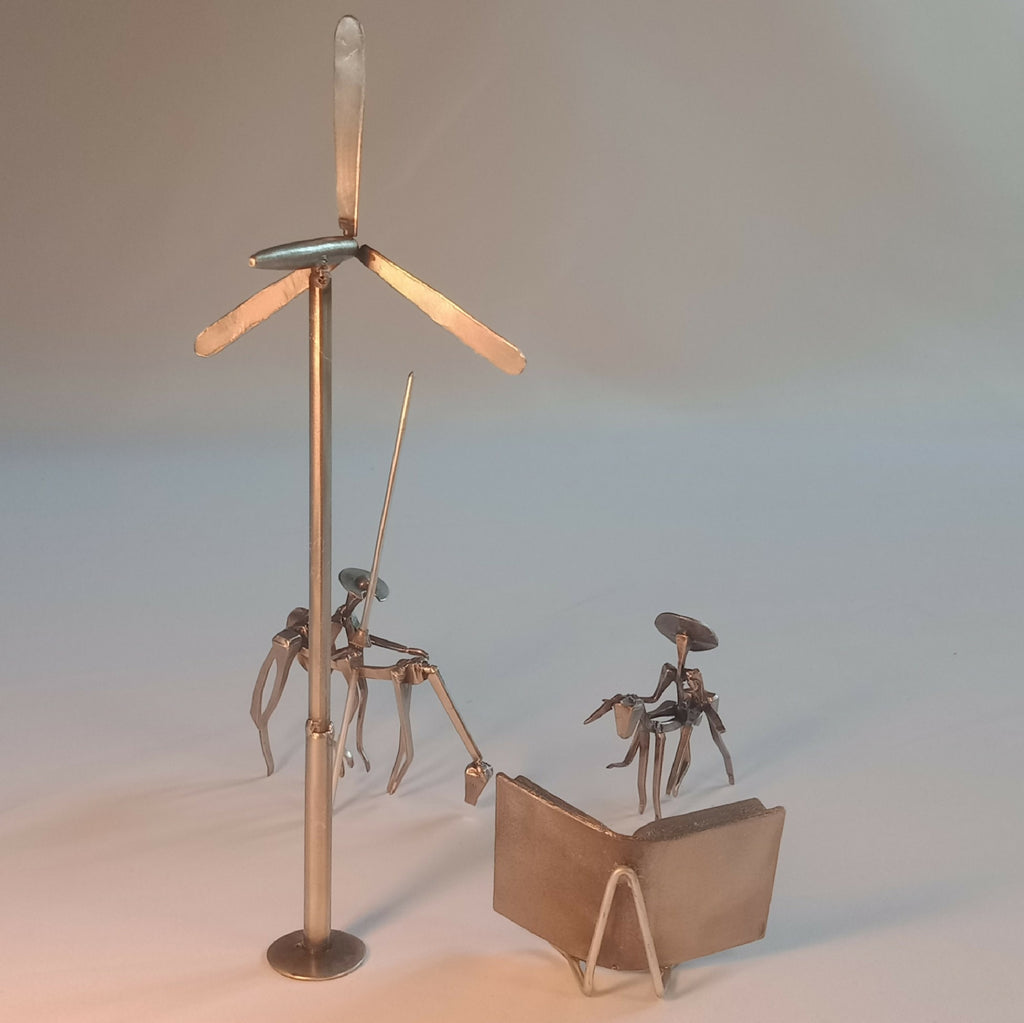 Sculpture en acier : chevalier sur mât, cape et personnages autour du livre.