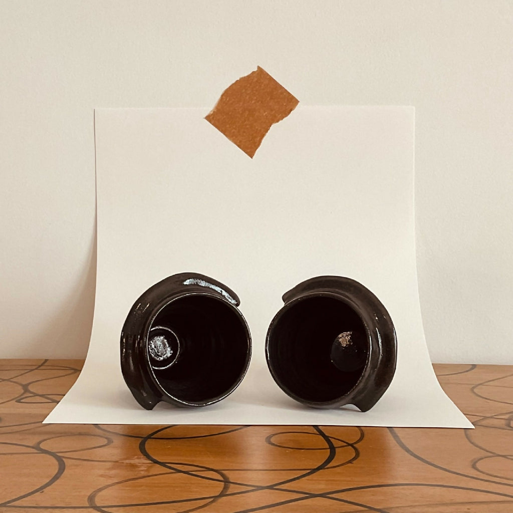 Deux tasses à café sombres, vues de dessus avec rebords arrondis