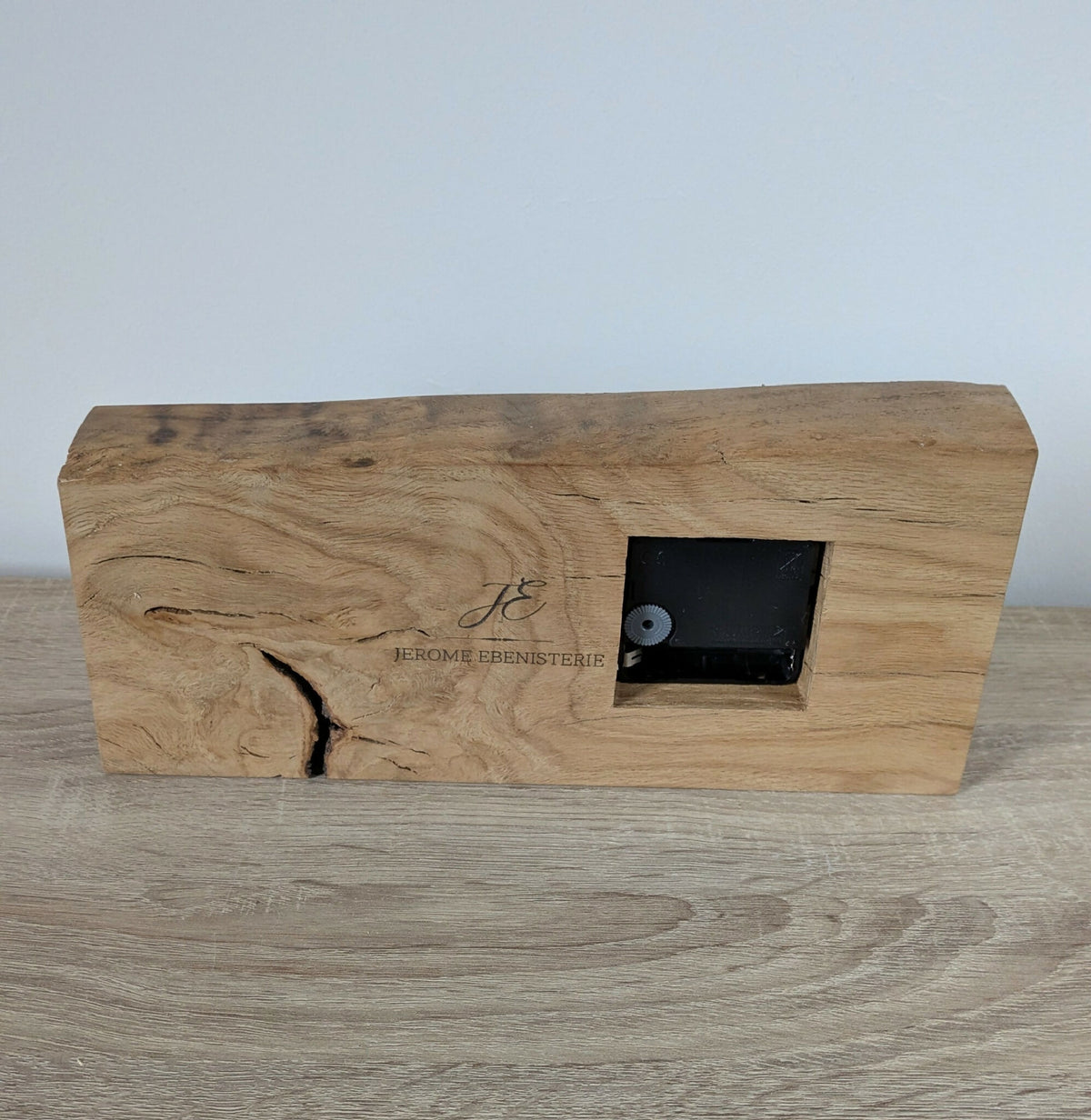 Horloge de bureau en bois clair avec cadran carré et mécanisme encastré.