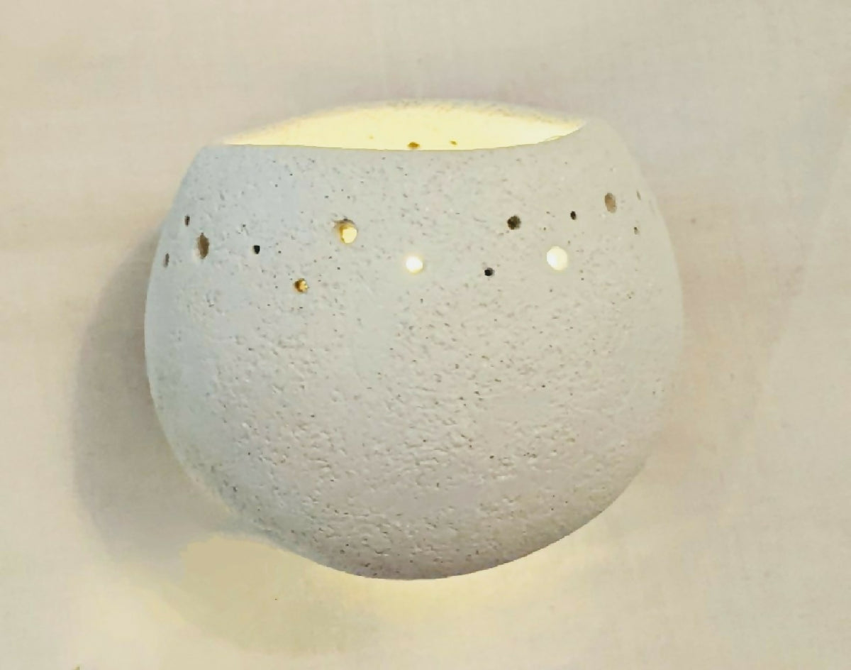 Applique murale blanche texturée, forme arrondie avec points décoratifs et éclairage en haut