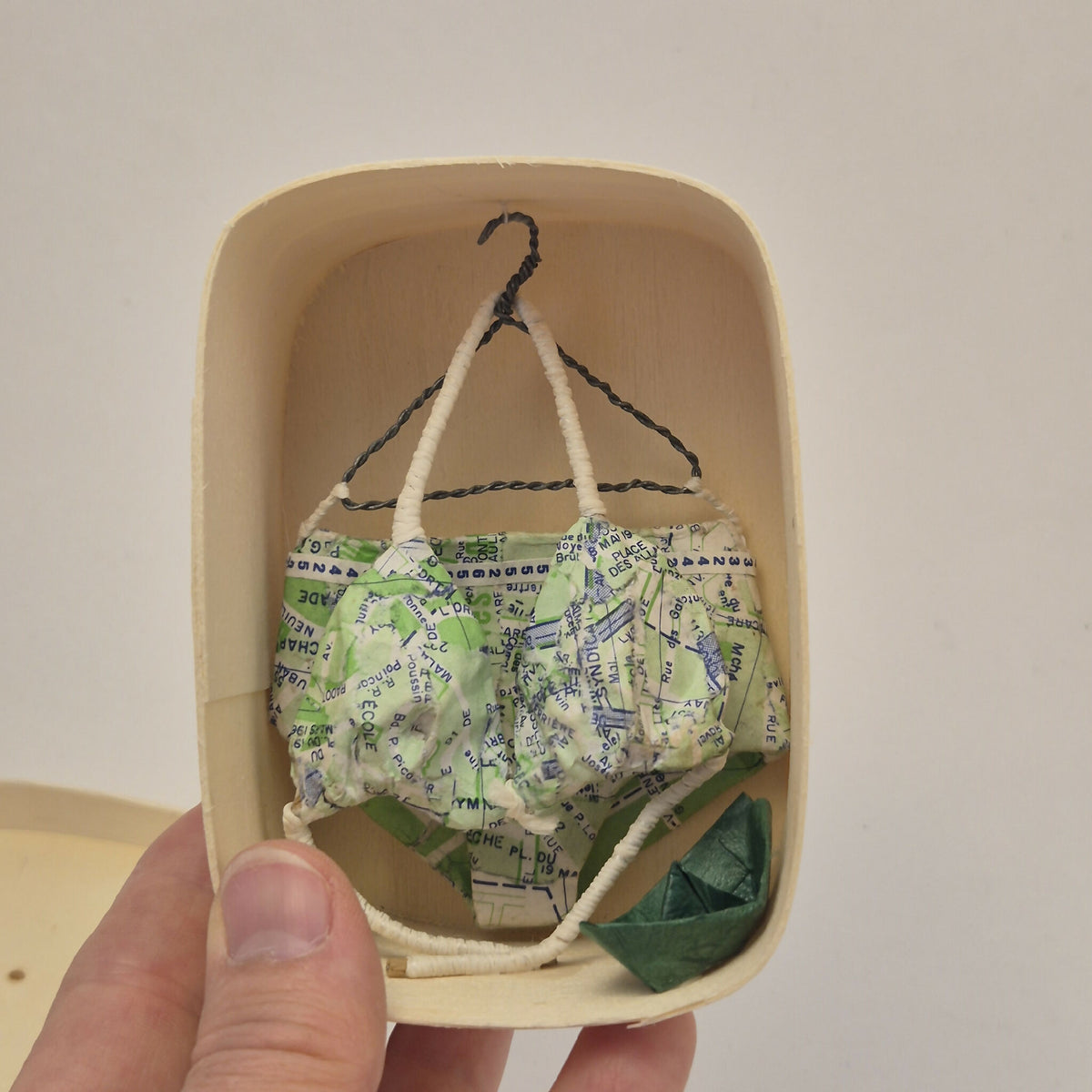 Maillot de bain miniature dans une boîte en bois, tenue suspendue au cintre