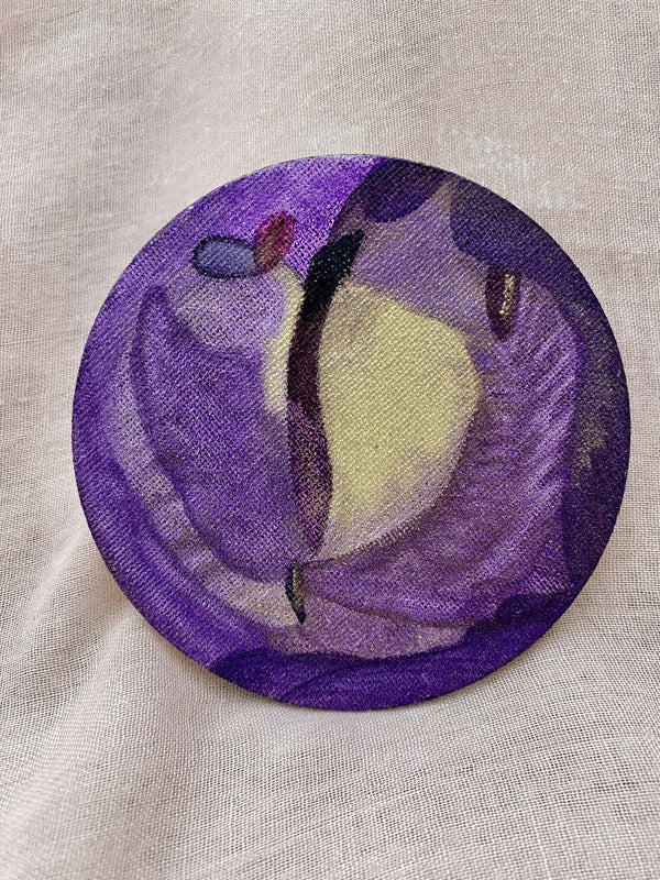 Badge rond en tissu violet avec motif cosmique, sur fond clair