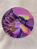Étiquette ronde d’encre artistique violette, motifs abstraits multicolores.