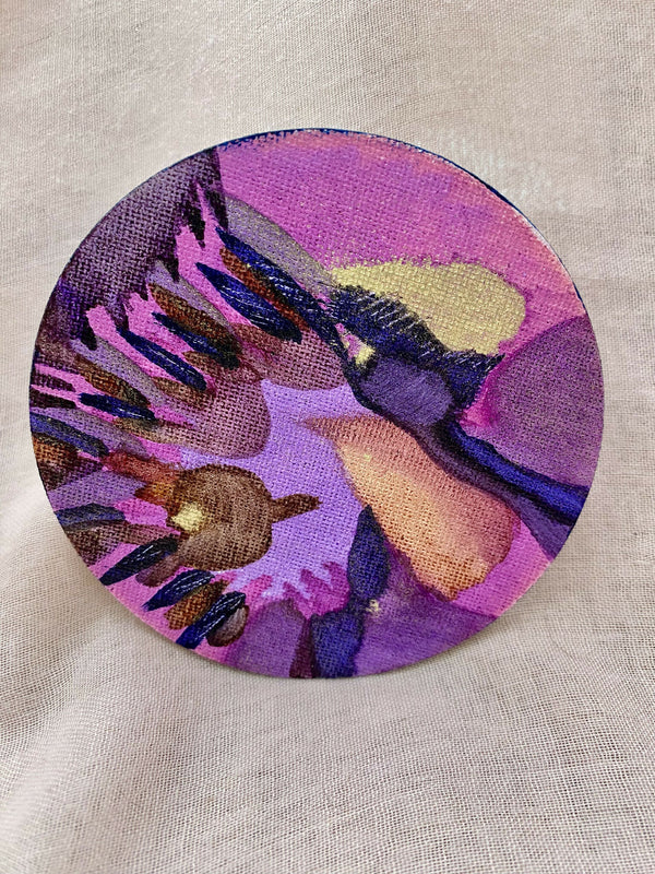 Étiquette ronde d’encre artistique violette, motifs abstraits multicolores.