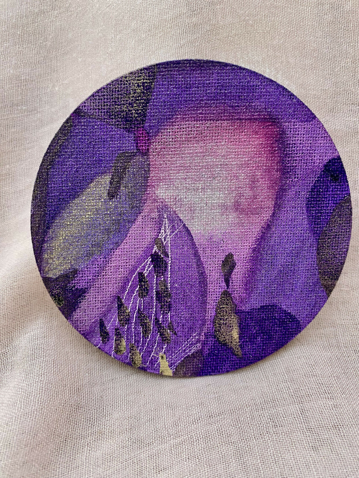 T-shirt en tissu clair avec grand motif rond violet, détails floraux et abstraits
