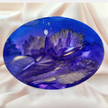Encre violette et bleue sur motif ovale de paysage montagneux, touches lumineuses