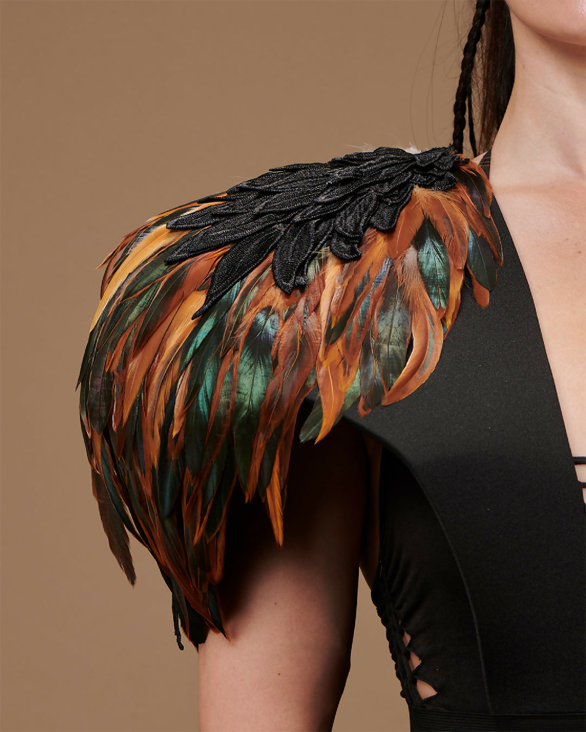 Épaulettes en plumes noires et orange-vert, détail sur l’épaule