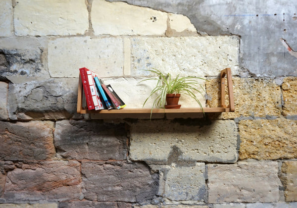 Étagère murale en bois clair avec support latéral et tablette.