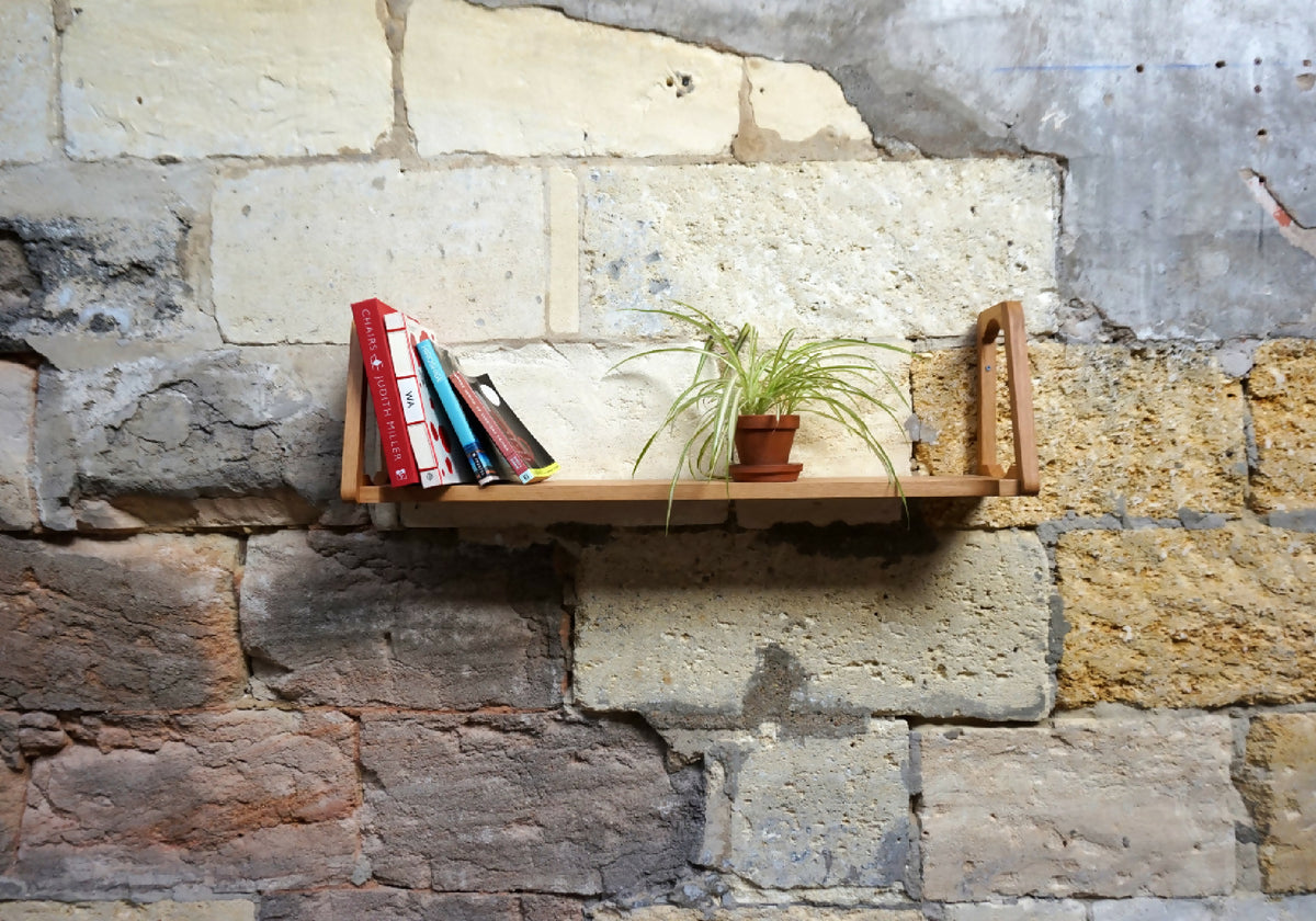 Étagère murale en bois clair avec support latéral et tablette.