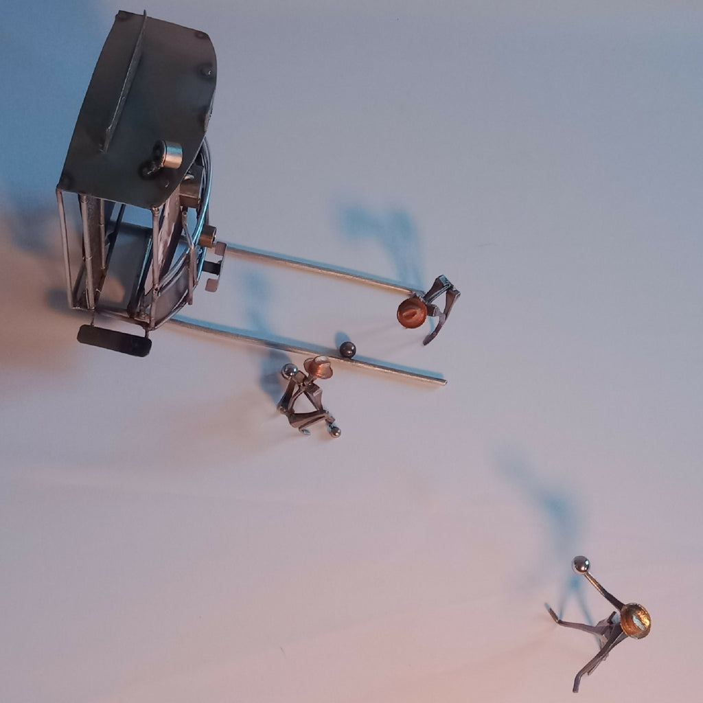 Sculpture miniature en métal : cabine et figurines sur base, vue de côté
