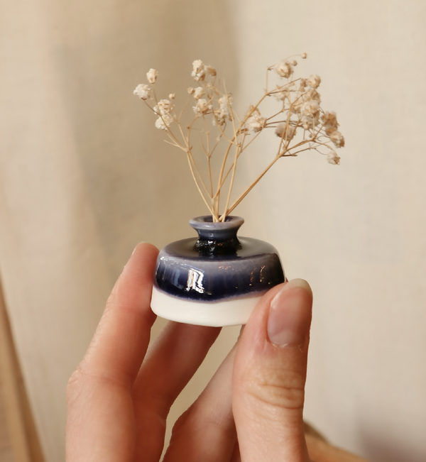 Mini-vase en porcelaine bleu nuit avec base blanche, tenu à la main, col étroit