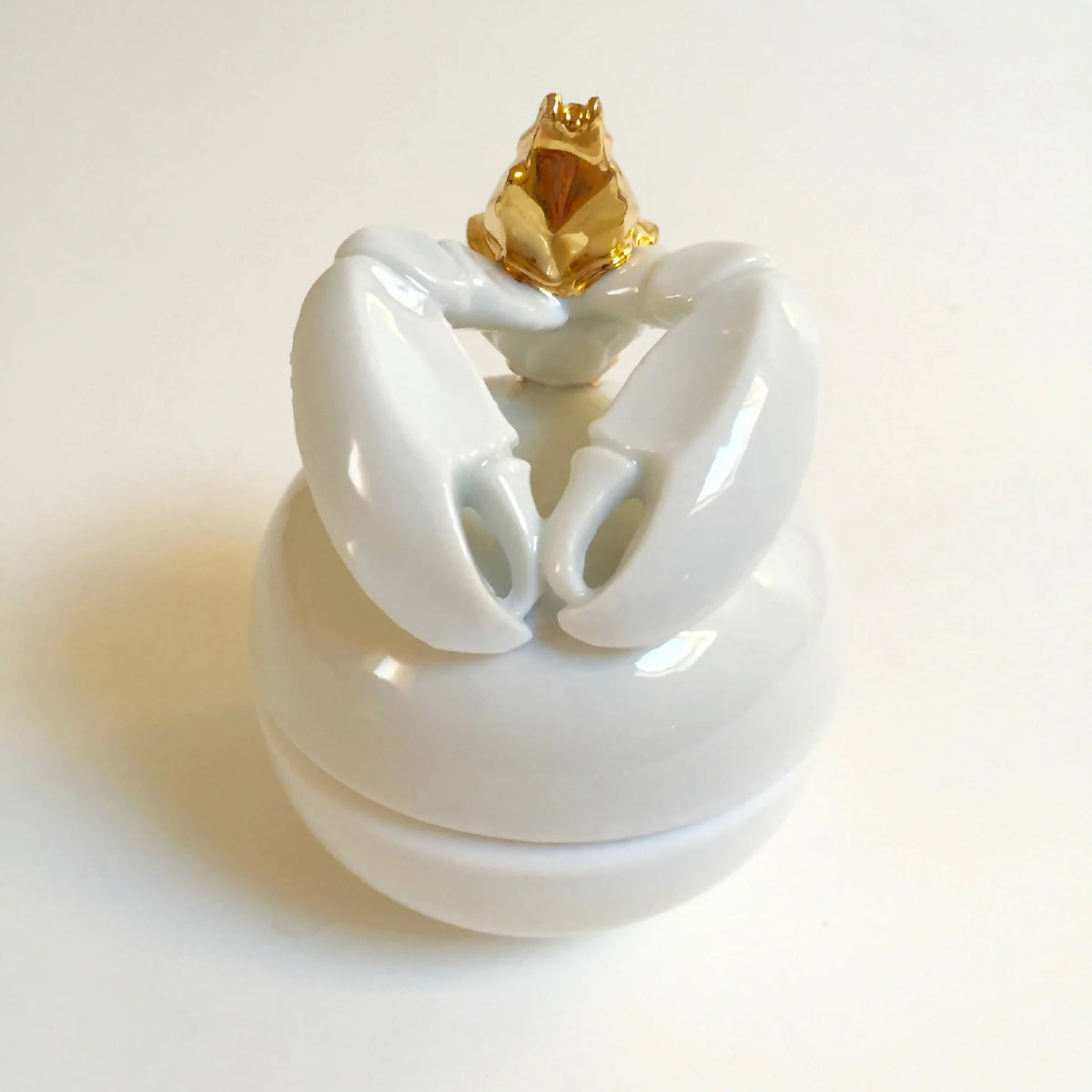Boîte à bijoux blanche ouverte, homard doré sur le couvercle