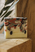 Savon solide rectangulaire, dessus marbré noir et rouge, bloc jaune pâle.