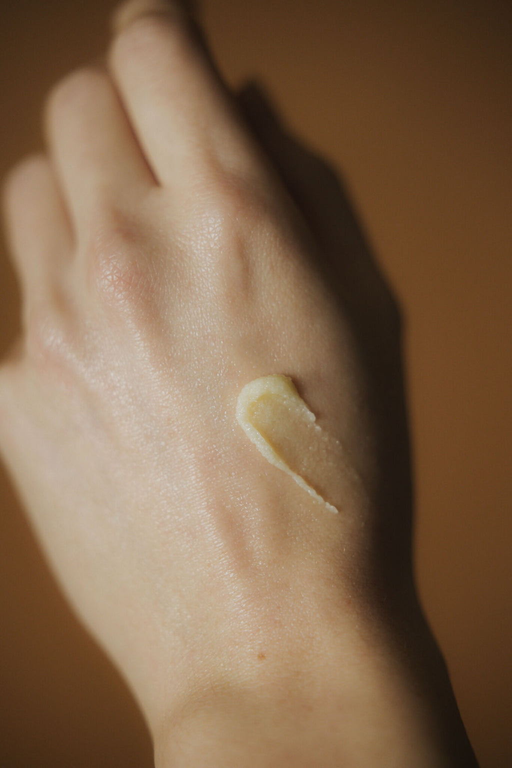 Baume noisette appliqué sur la peau, texture crème jaune pâle en trait.