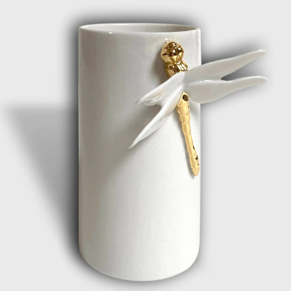 Vase cylindrique blanc avec libellule blanche et accents dorés, posé sur pied.