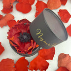 Bougie cylindrique noire « Nez dans les Fleurs », couvercle ouvert, fleurs rouges.