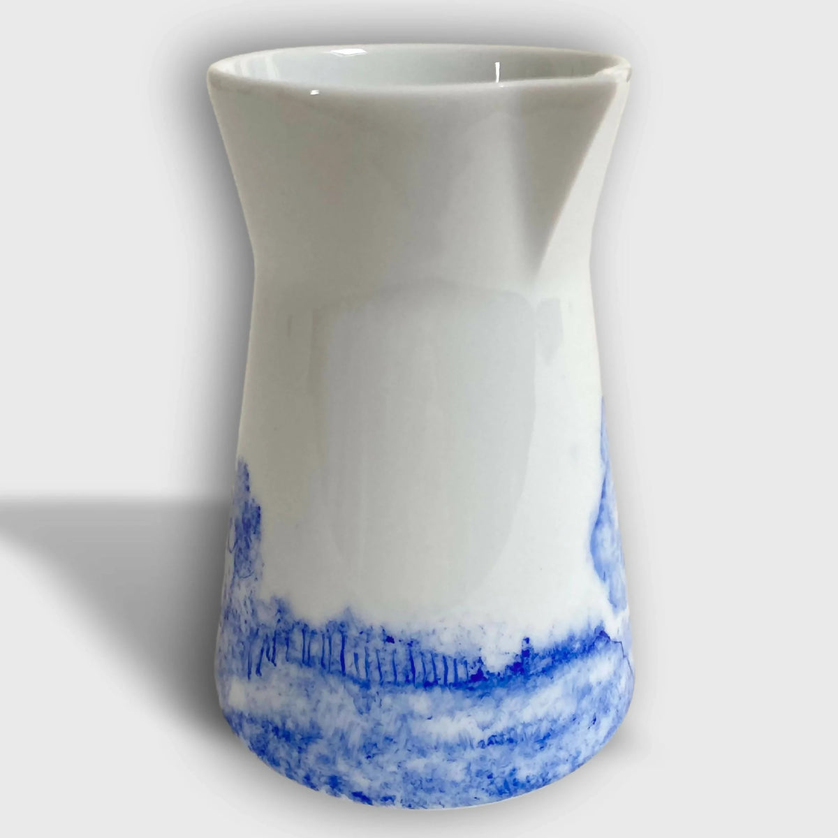 Pichet à lait en céramique blanc, motif paysage bleu près du bas