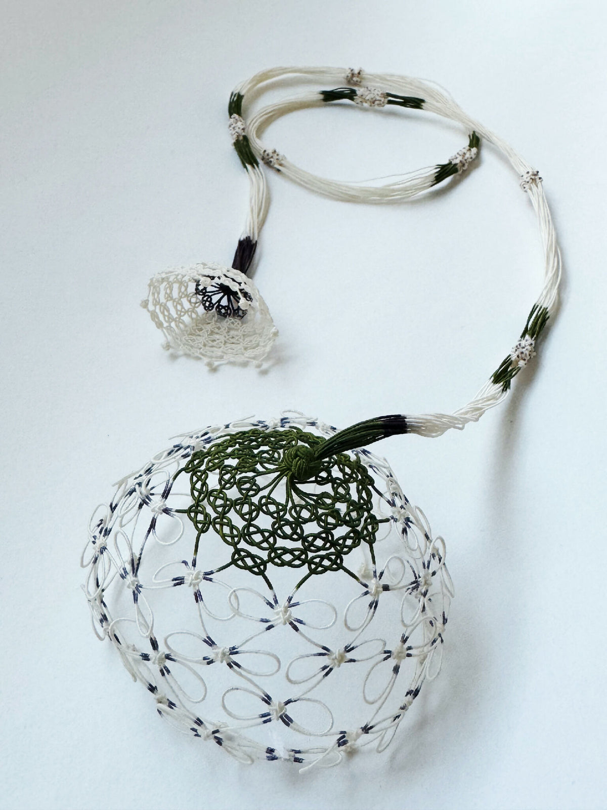 Collier en soie blanc avec cordons et grand pendentif rond en dentelle.