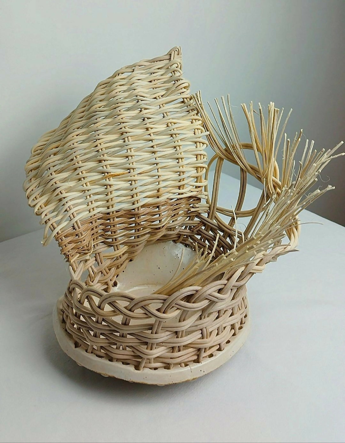 Photophore en osier tressé beige avec brins végétaux et base ronde