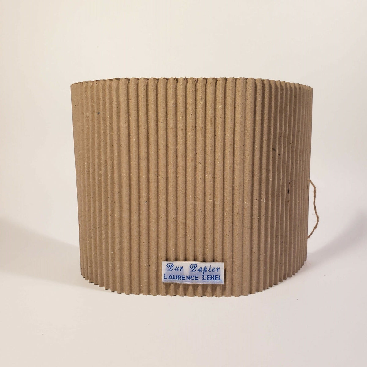 Tube en carton ondulé beige avec étiquette « Our Papier » « Laurence Lekerel »
