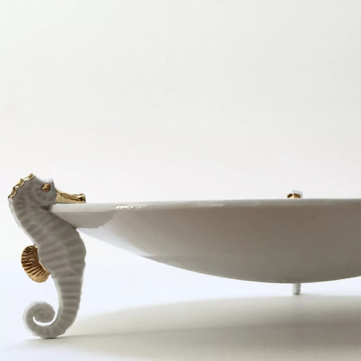 Centre de table hippocampe : base avec hippocampe gris strié et plat allongé blanc.