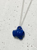 Pendentif en porcelaine bleue de forme irrégulière sur chaîne en argent.