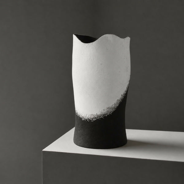 Vase décoratif grand cylindre noir, intérieur clair, posé sur socle