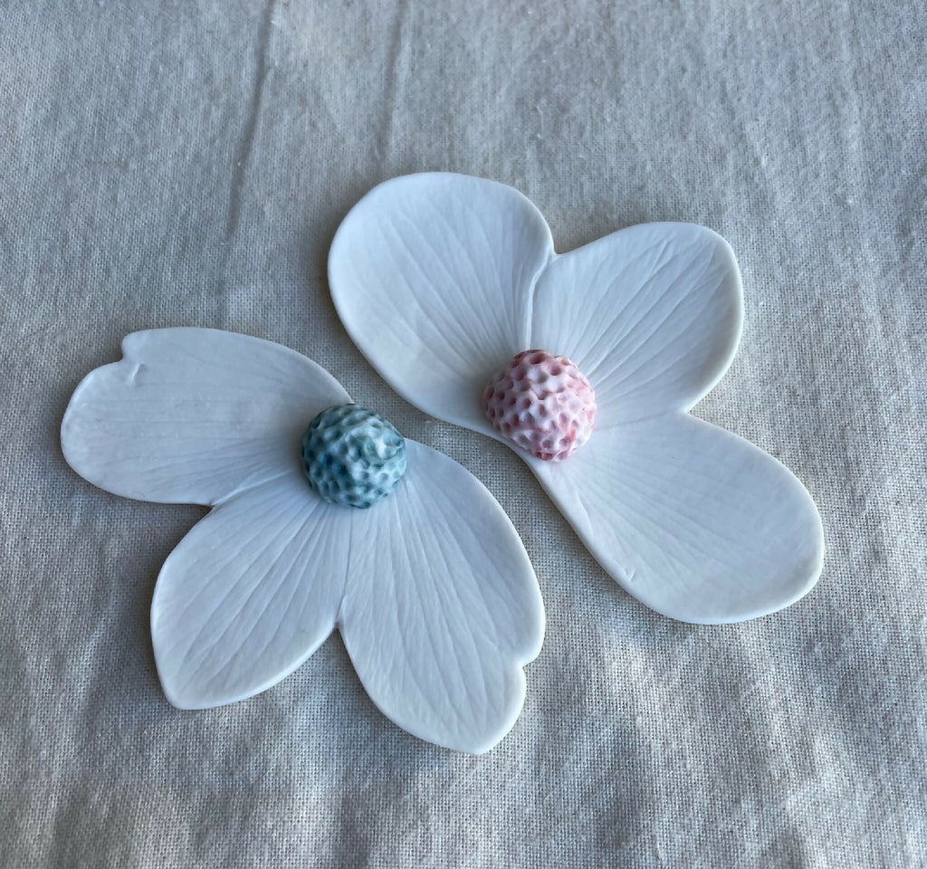 Broches florales en porcelaine aimantée, pétales bleu clair, centres bleu et rose.