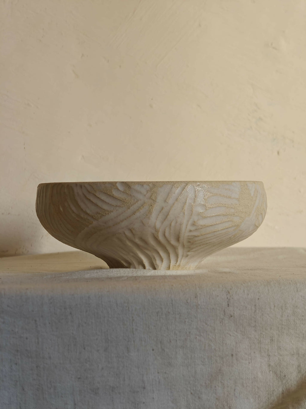 Bol en céramique sculptée, couleur crème, base large et bord arrondi.