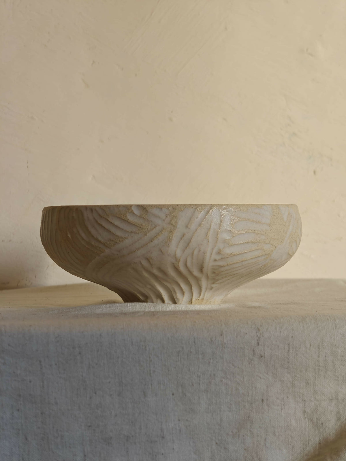 Bol en céramique sculptée, couleur crème, base large et bord arrondi.