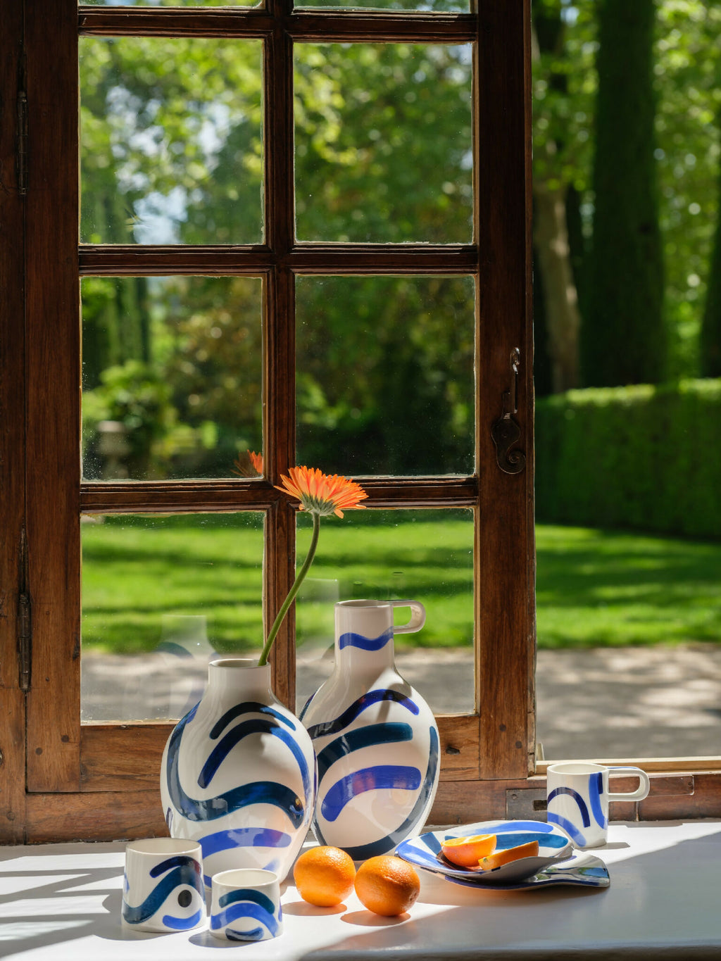 Ensemble de grandes tasses trapèze en céramique blanche, motifs bleu et orange.