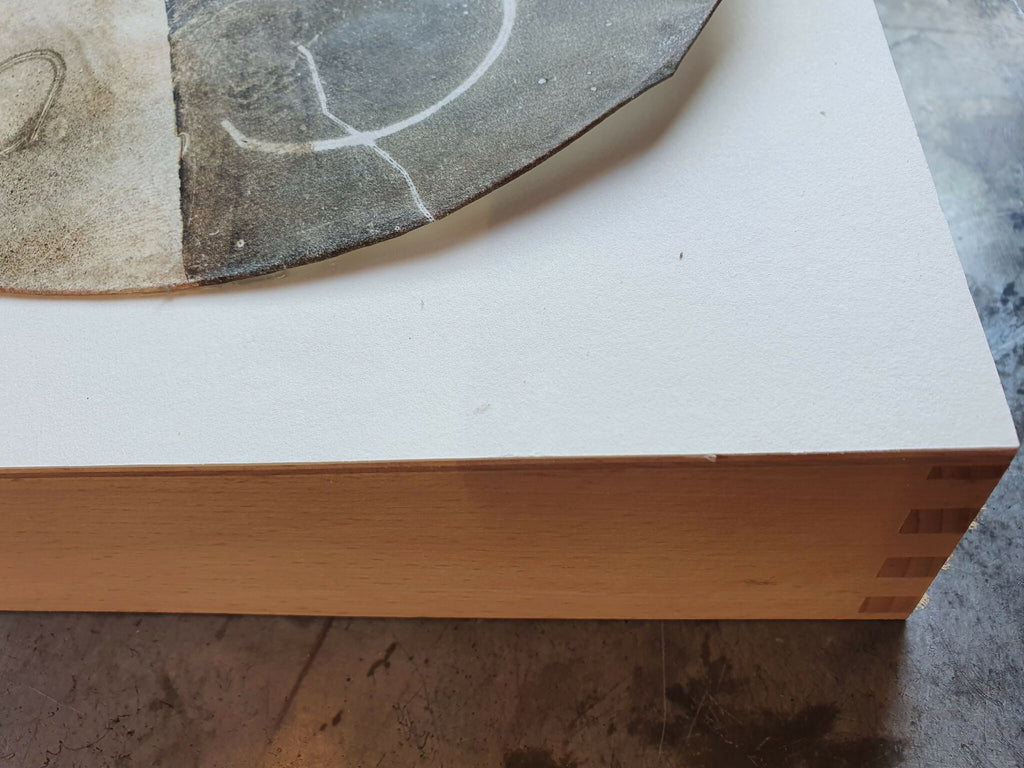 Gravure montée sur cuivre, vue du bord : fond clair et partie d’une forme circulaire