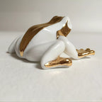 Figurine de grenouille en porcelaine blanche, vue de dos et pattes dorées