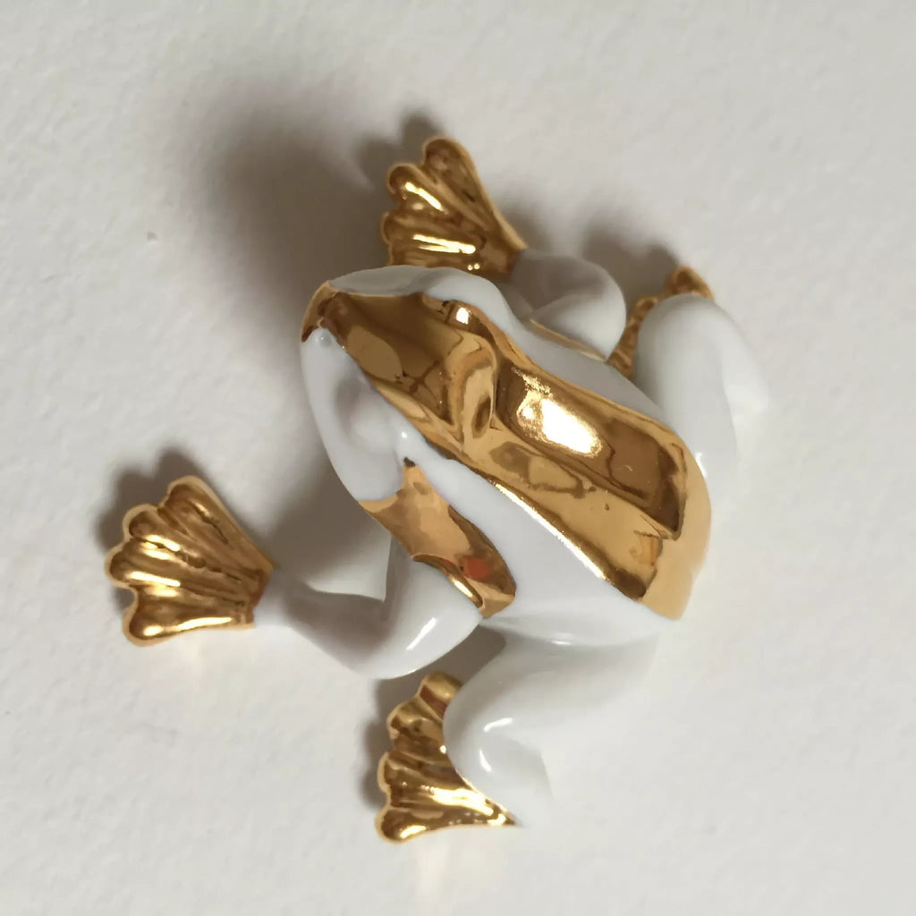 Figurine de grenouille en porcelaine blanche, vue du dessous avec aplats dorés