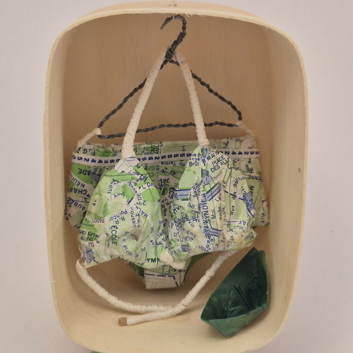 Maillot de bain miniature dans une boîte en bois, imprimé carte multicolore et poche verte