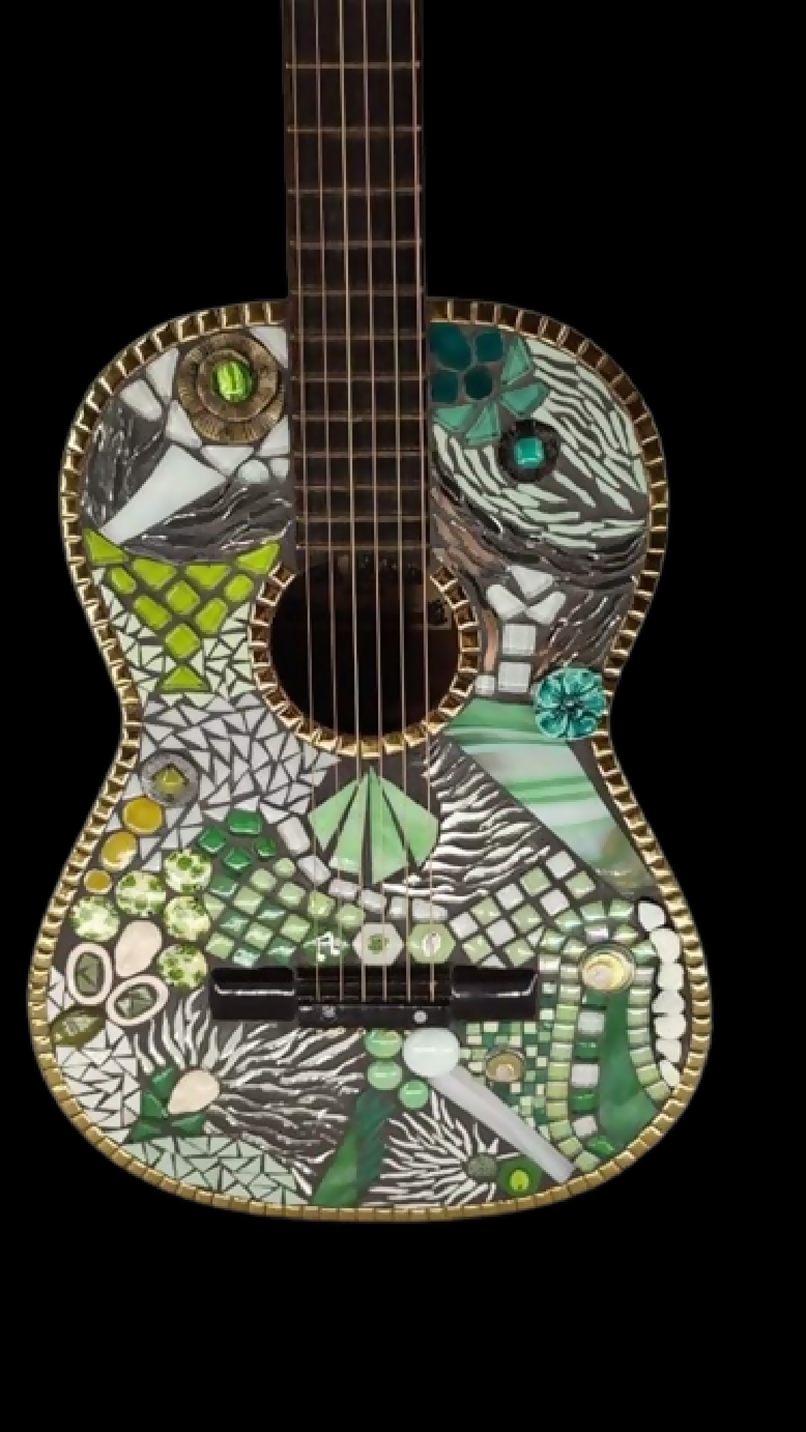 Guitare décorative mosaïque verte et blanche, gros plan sur la caisse et le cordier.